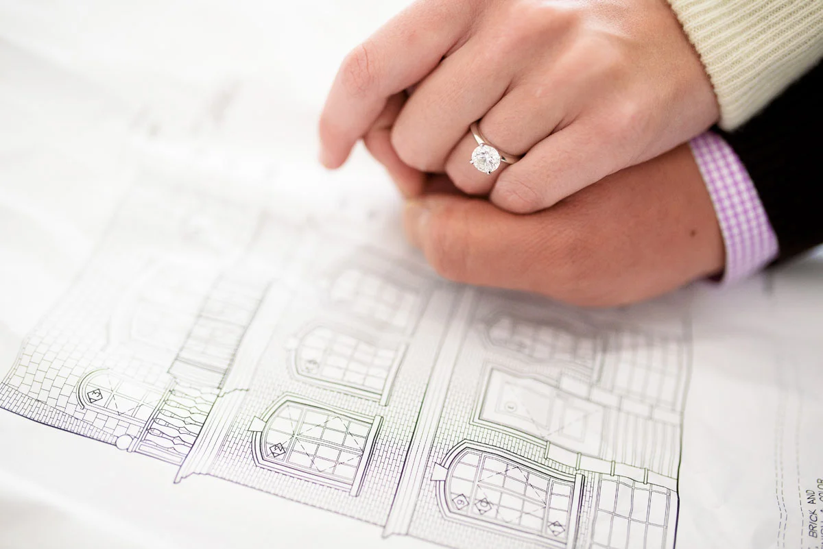 Couple looks at the blue prints of their Wicker Park home during their Chicago engagement session. 