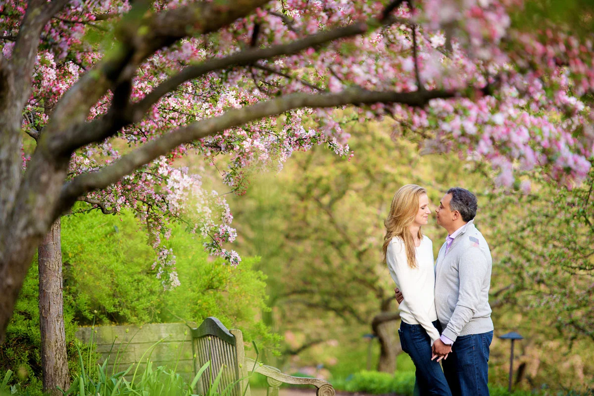 The couple is framed by flowers in bloom at the Chicago Botanic Gardens during their engagement session. 