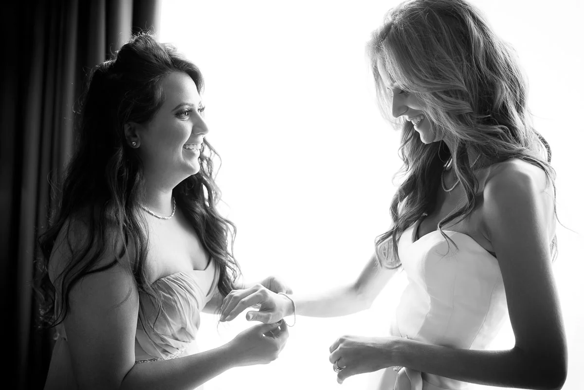 The maid-of-honor helps the bride get ready at the Trump Tower Chicago on her wedding day.