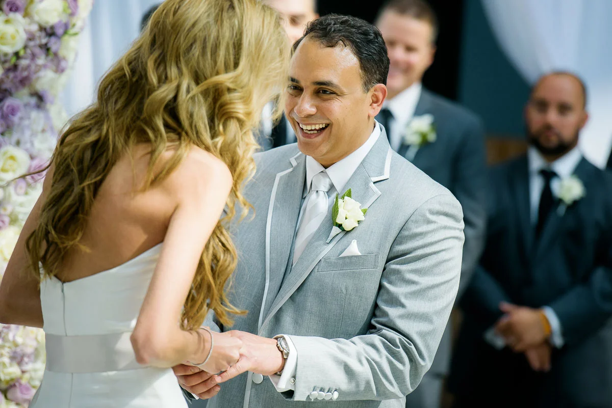 Bride and groom share a laugh during their wedding ceremony in the Winter Garden at the Harold Washington Library Chicago. 