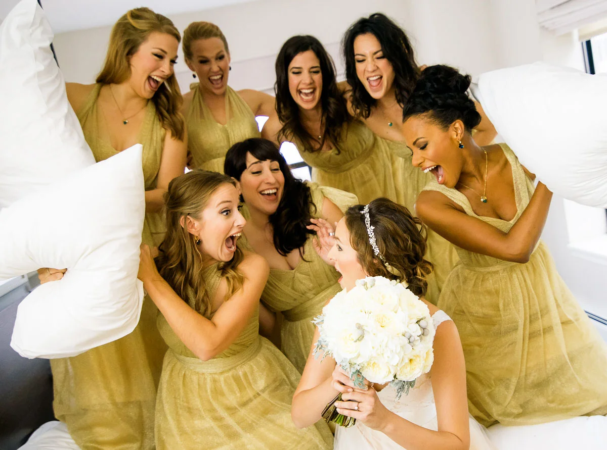 Fun and creative bridal party photo of a mock pillow fight on the wedding day at the James Hotel. 