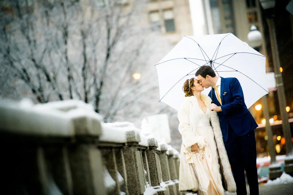Bride & groom kiss will walking down Monroe St. in Chicago on their wedding day.