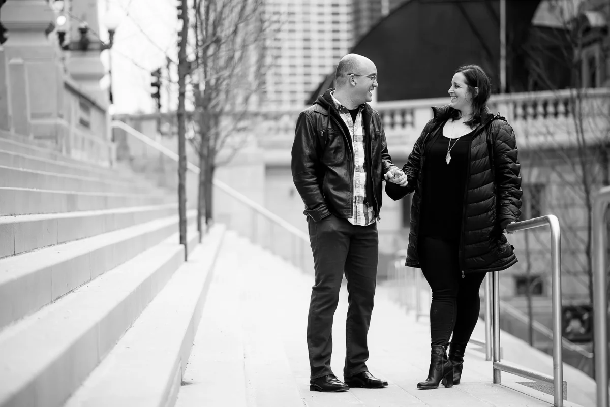 A couple shares a laugh along the Riverwalk during their Chicago engagement session.