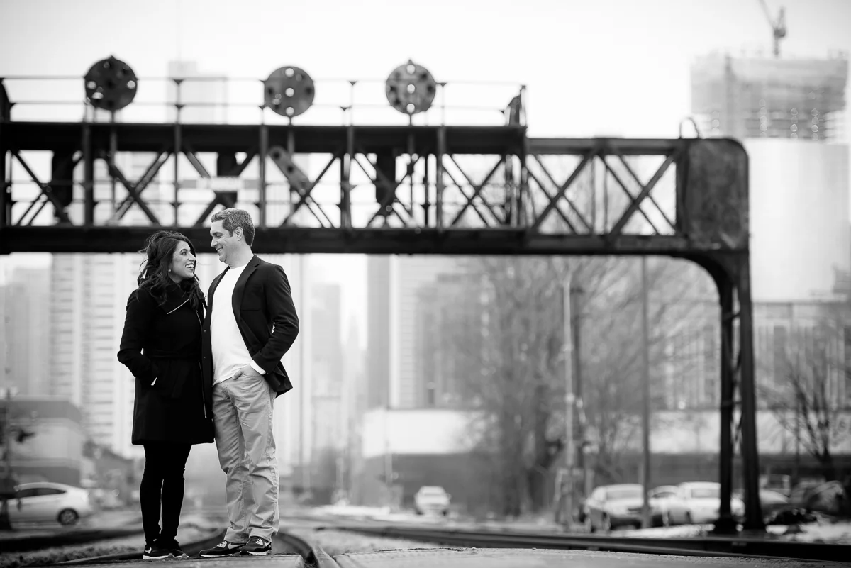 The couple stands along the train tracks in the Fulton Market area during their Chicago engagement session. 