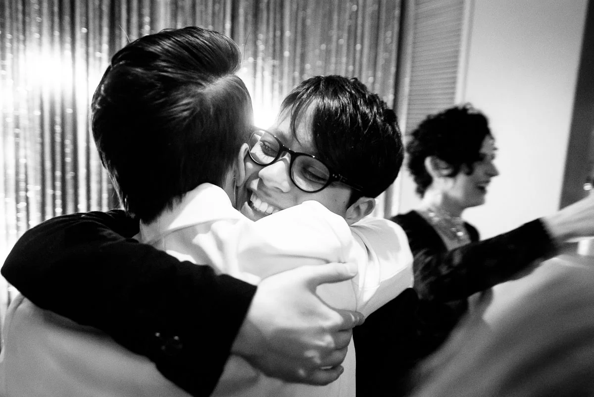 Same sex couple celebrates with friends after their wedding ceremony at Tiny Lounge. 