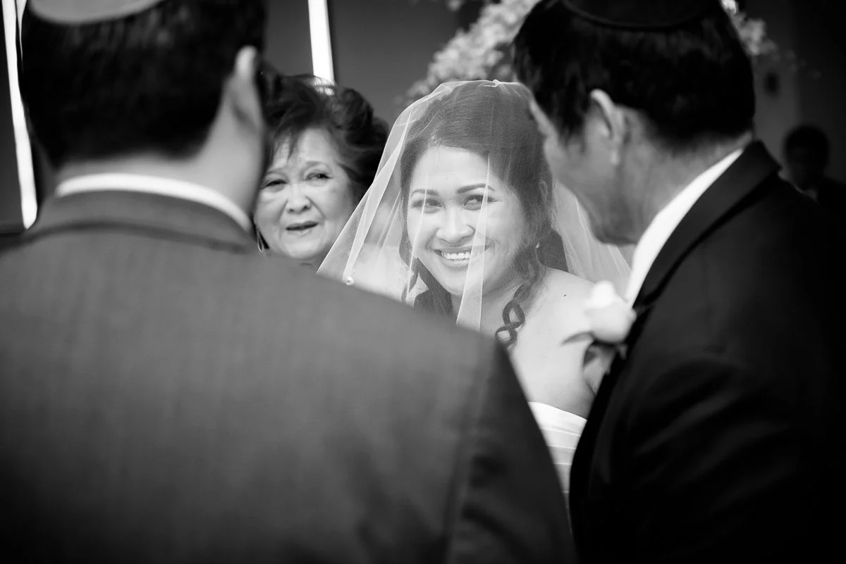 The bride smiles as she is given away by her father during her wedding at the DoubleTree Skokie. 