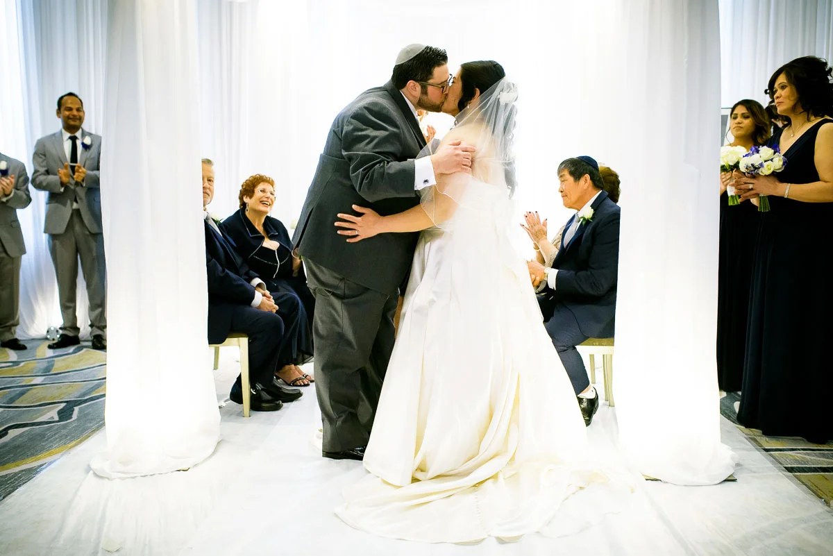 First kiss under the chuppah during a jewish wedding ceremony at the DoubleTree Skokie.