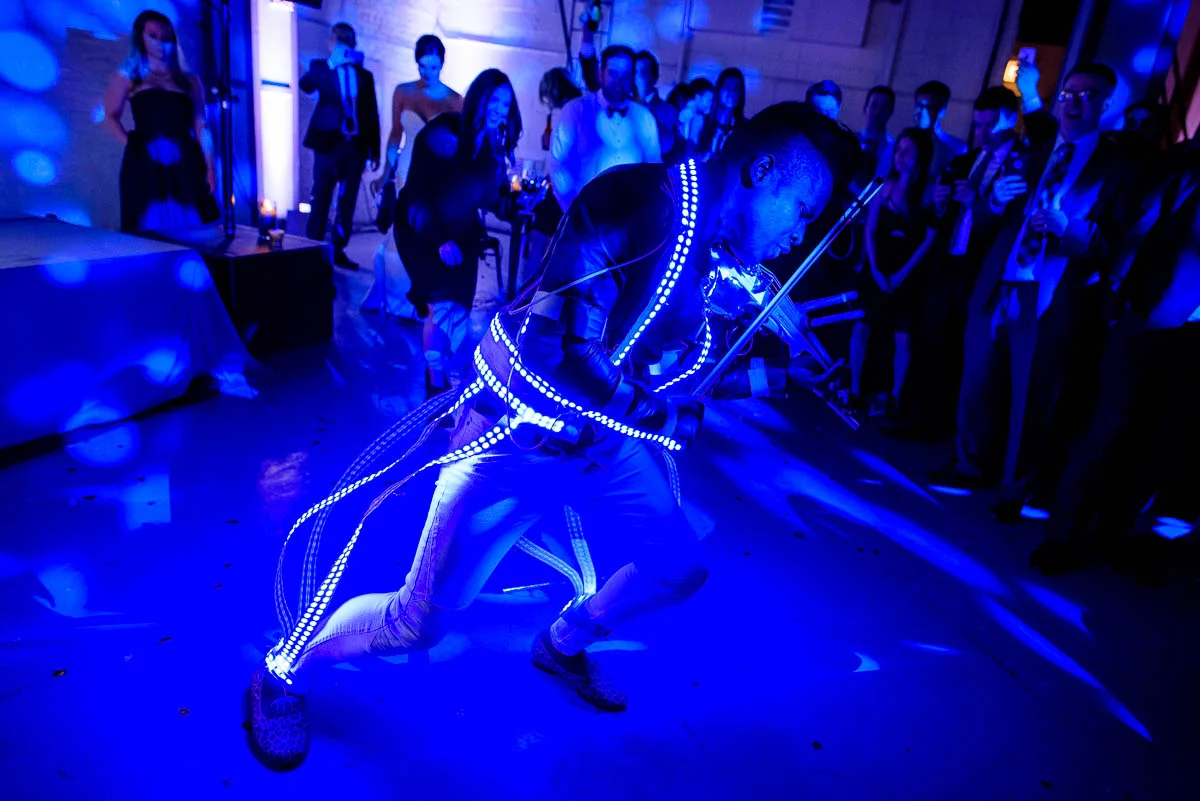 DJ/Violinist Timothee Lovelock wears and LED lighted suit during a wedding reception at Moonlight Studios Chicago. 