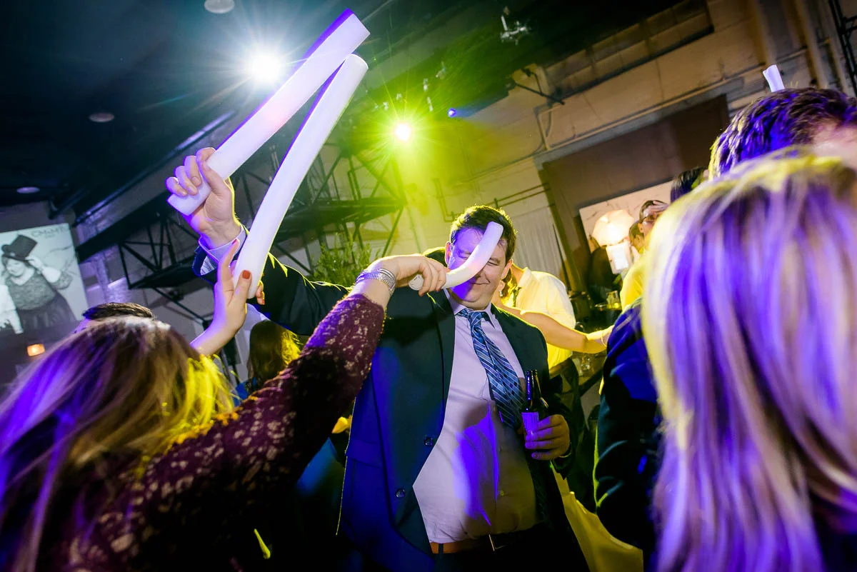 Guest is hit in the face with a lighted foam stick during a Moonlight Studios Chicago wedding reception. 