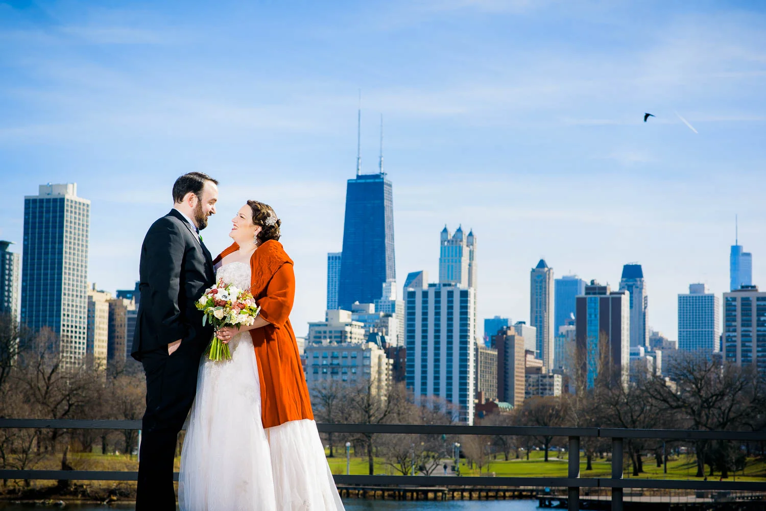 Creative portrait of bride and groom with the Chicago Skyline at Lincoln Park. 