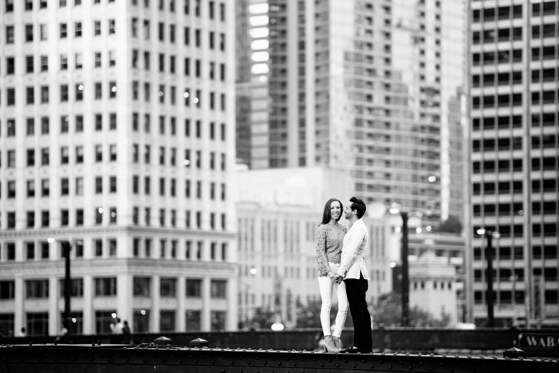 Couple stands on the State St. Bridge during the Chicago Riverwalk engagement session. 