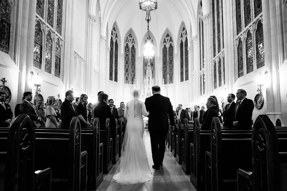 Father walks his daughter down the aisle during her winter Chicago wedding at St. James Chapel. 