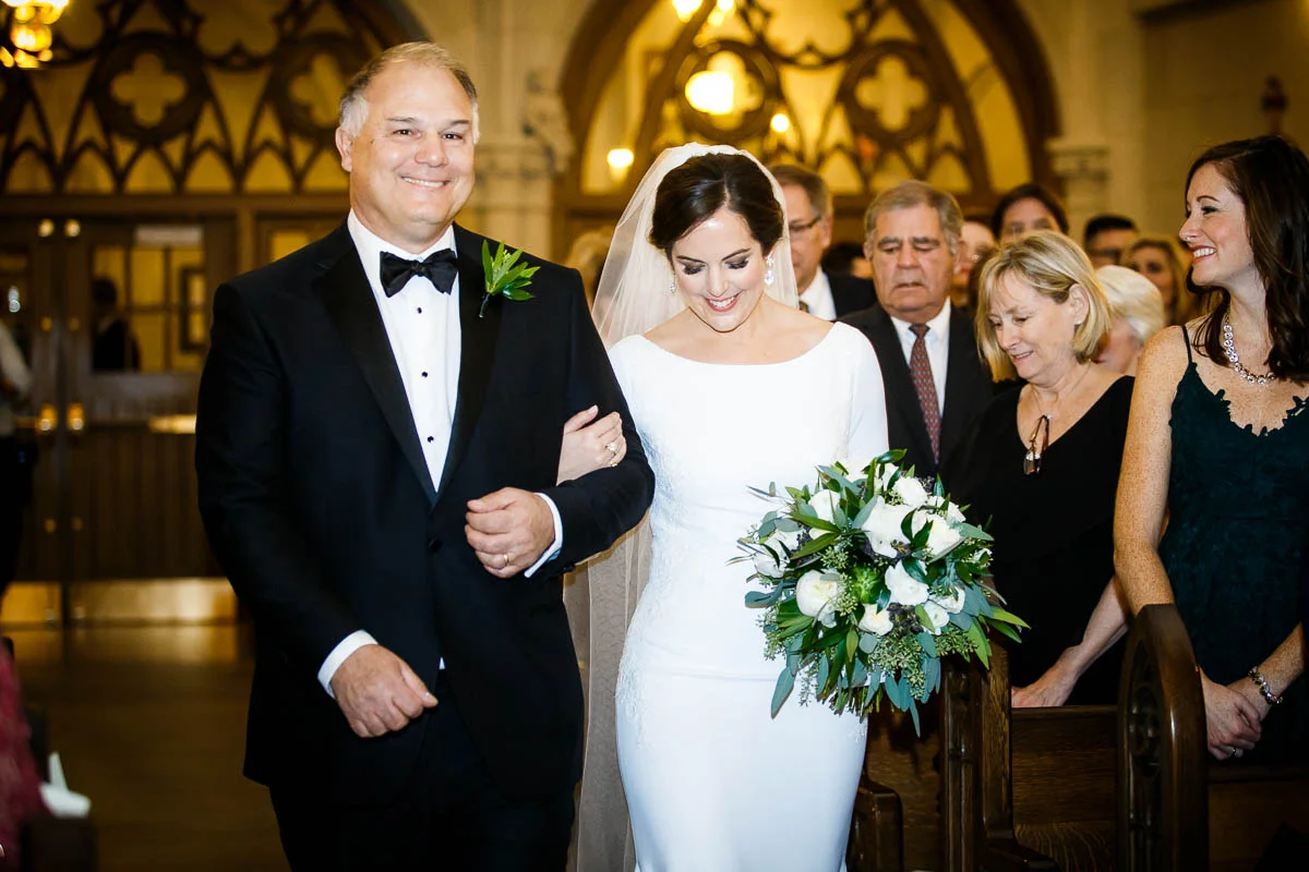 Father walks his daughter down the aisle during her winter Chicago wedding at St. James Chapel. 