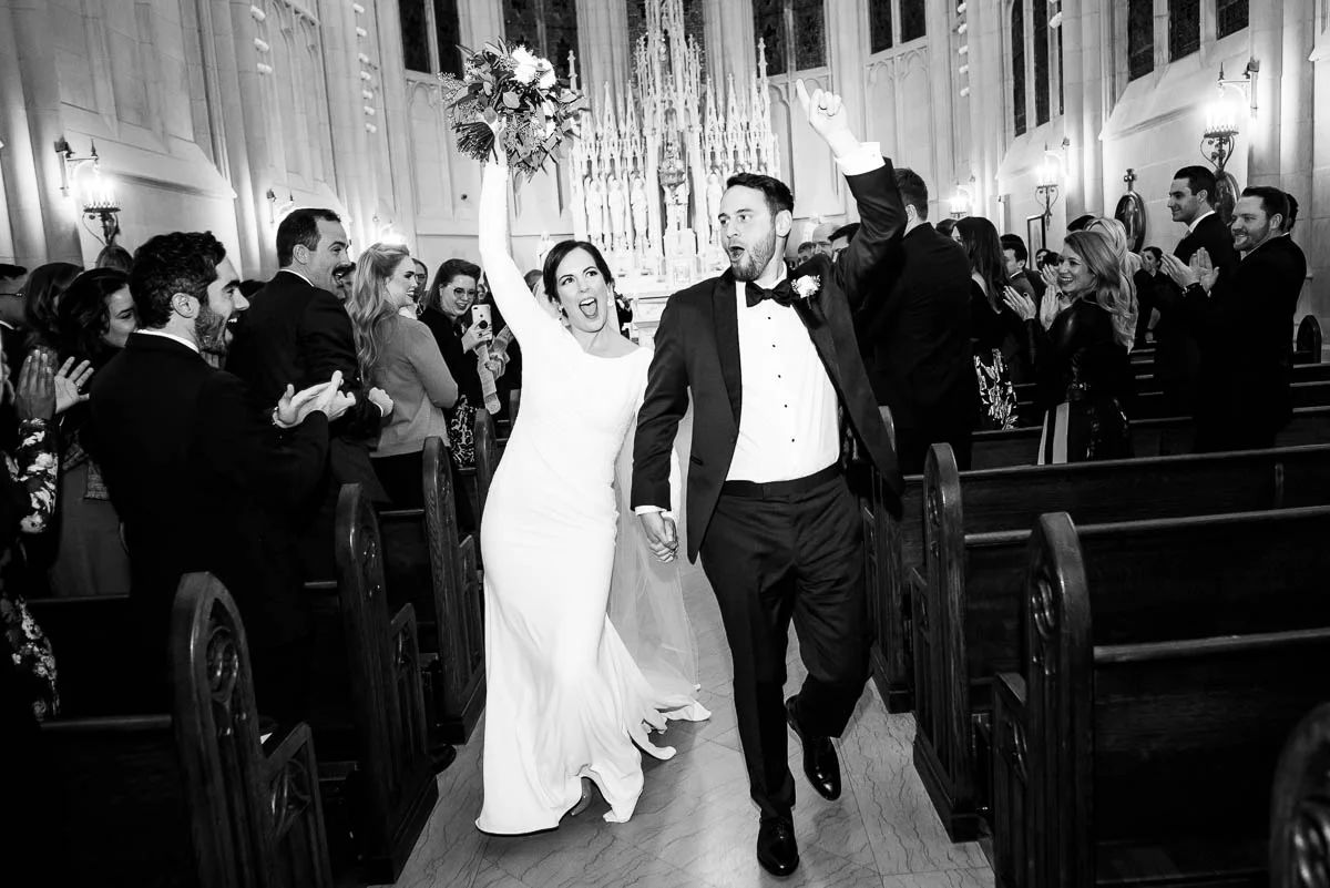 Bride & groom celebrate as they walk down the aisle after their St. James Chapel Chicago wedding ceremony. 