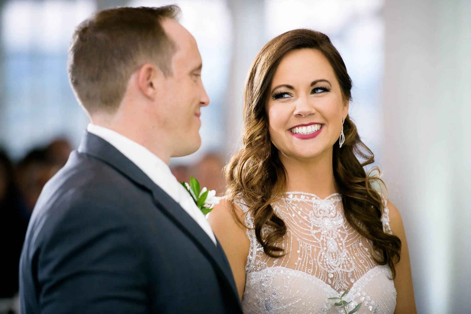 Bride and groom laugh together during their wedding ceremony at the Manor House in Littleton, Colorado. 