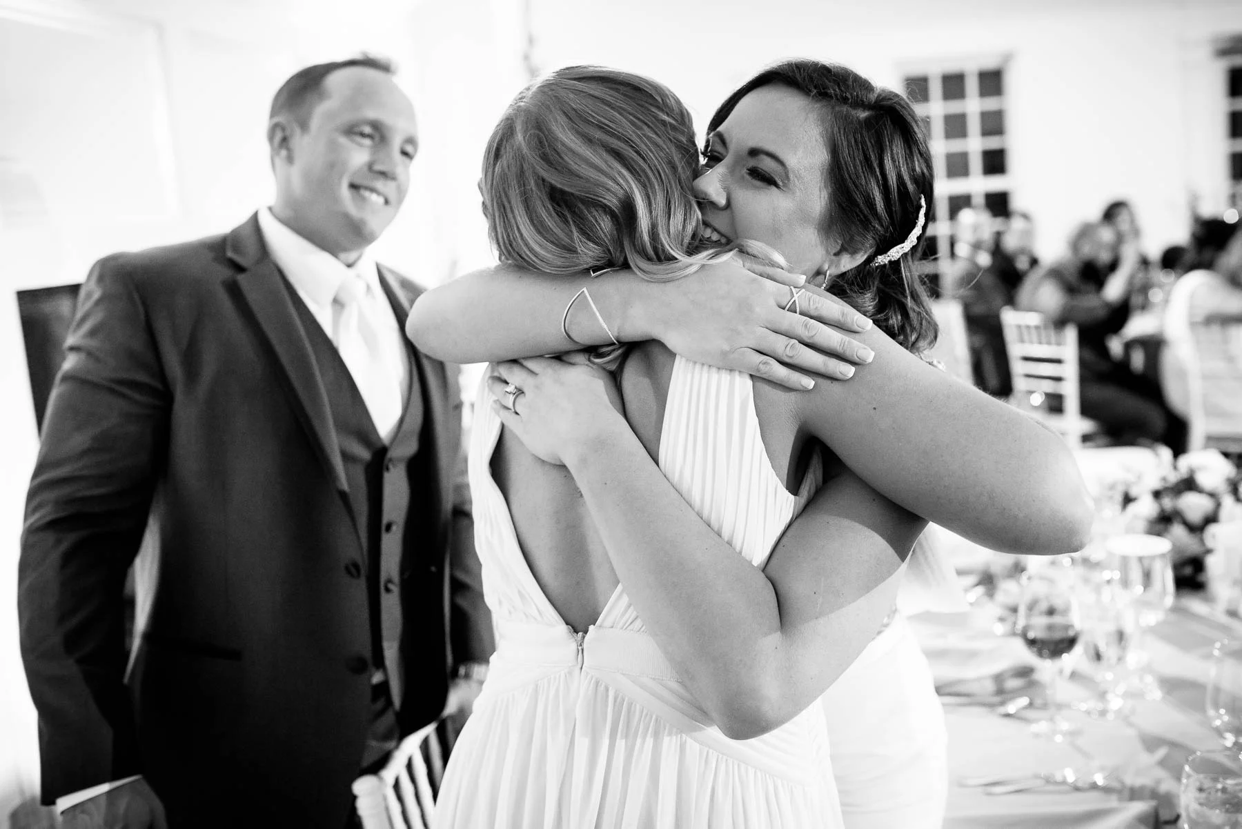 Maid-of-honor and bride hug after her speech during a wedding at the Manor House in Littleton, Colorado.