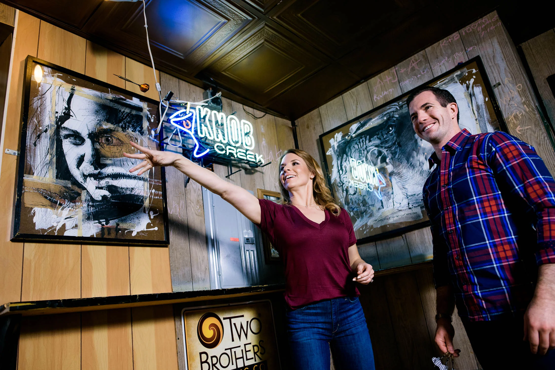 Bride and groom playing darts during their Chicago engagement session at Jake's Pub. 