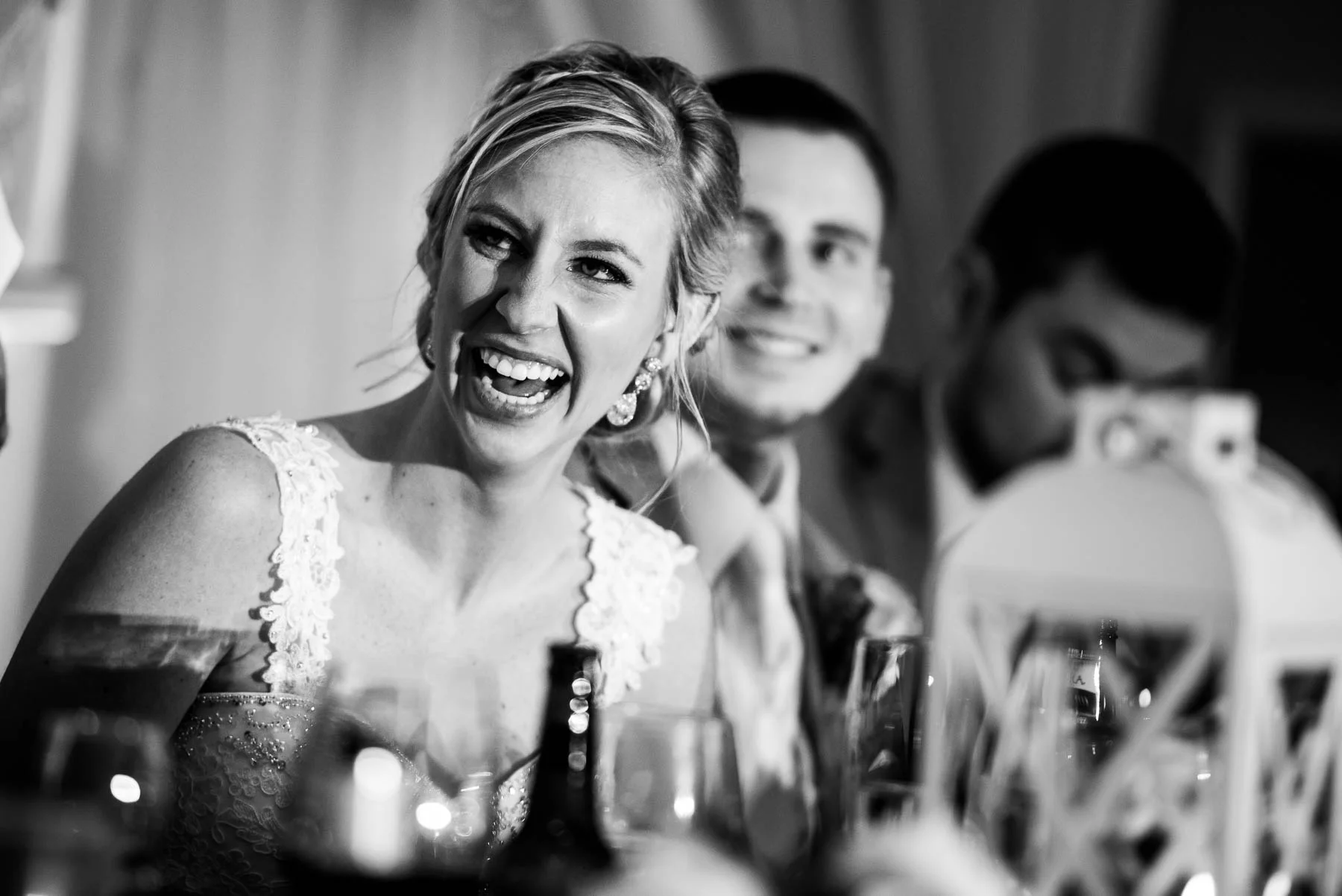 Bride and groom laugh during wedding party speeches at the St. Charles Country Club wedding. 