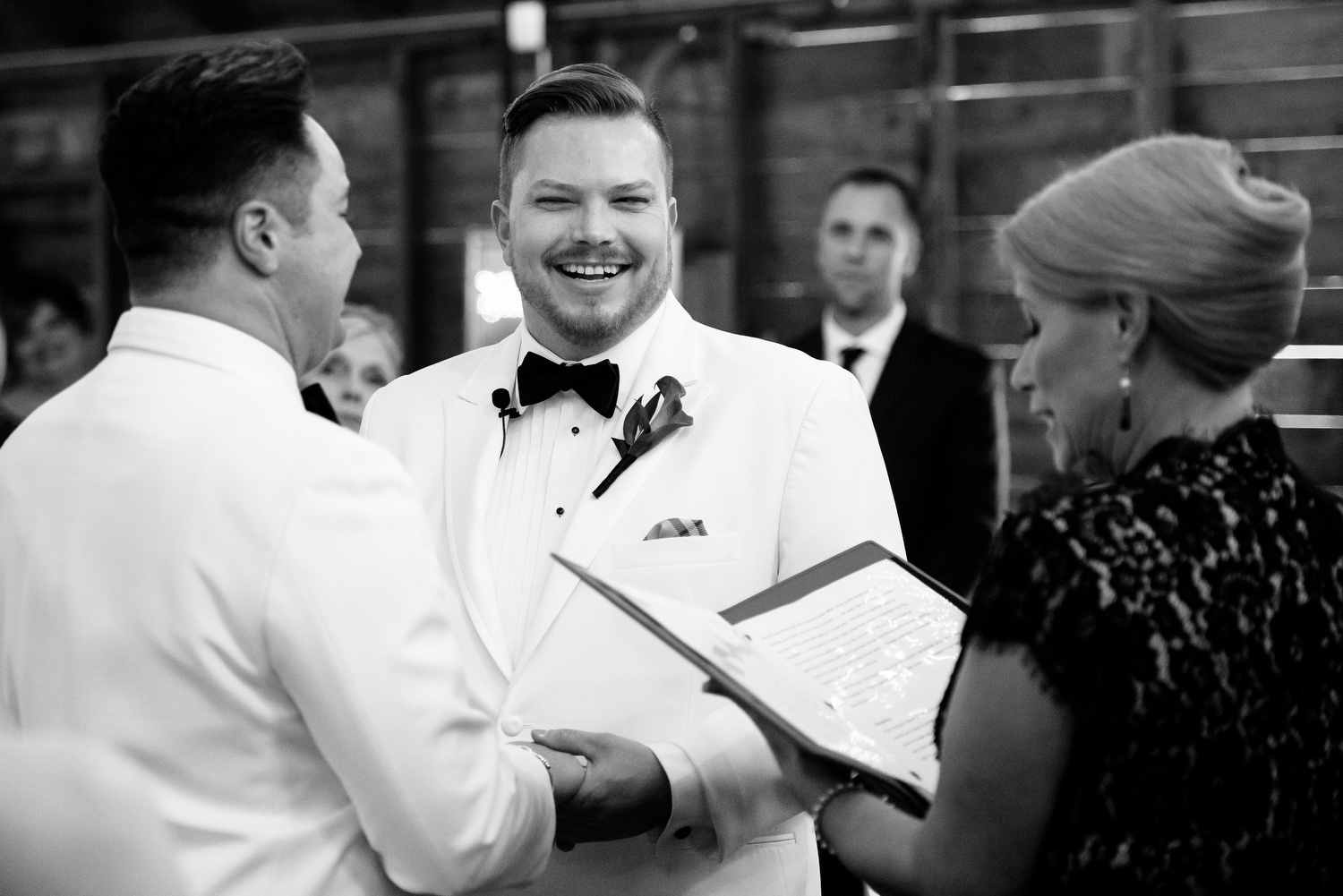 Grooms share a laugh during their wedding at Heritage Prairie Farm.