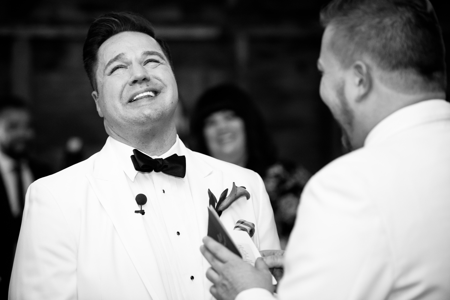 Grooms laugh during their wedding ceremony at Heritage Prairie Farm.