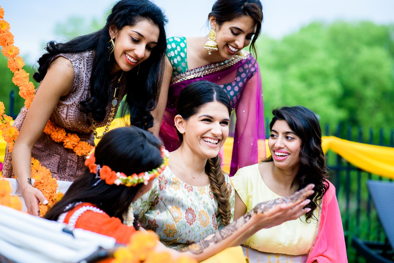 Bridesmaids with the bride while her henna is done during an Indian wedding mehndi in South Barrington, Illinois.