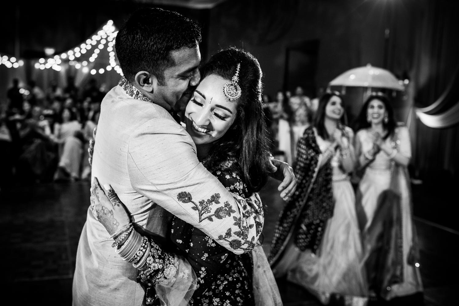 Bride and groom embrace during an Indian wedding sangeet at Stonegate Banquets in Hoffman Estates. 