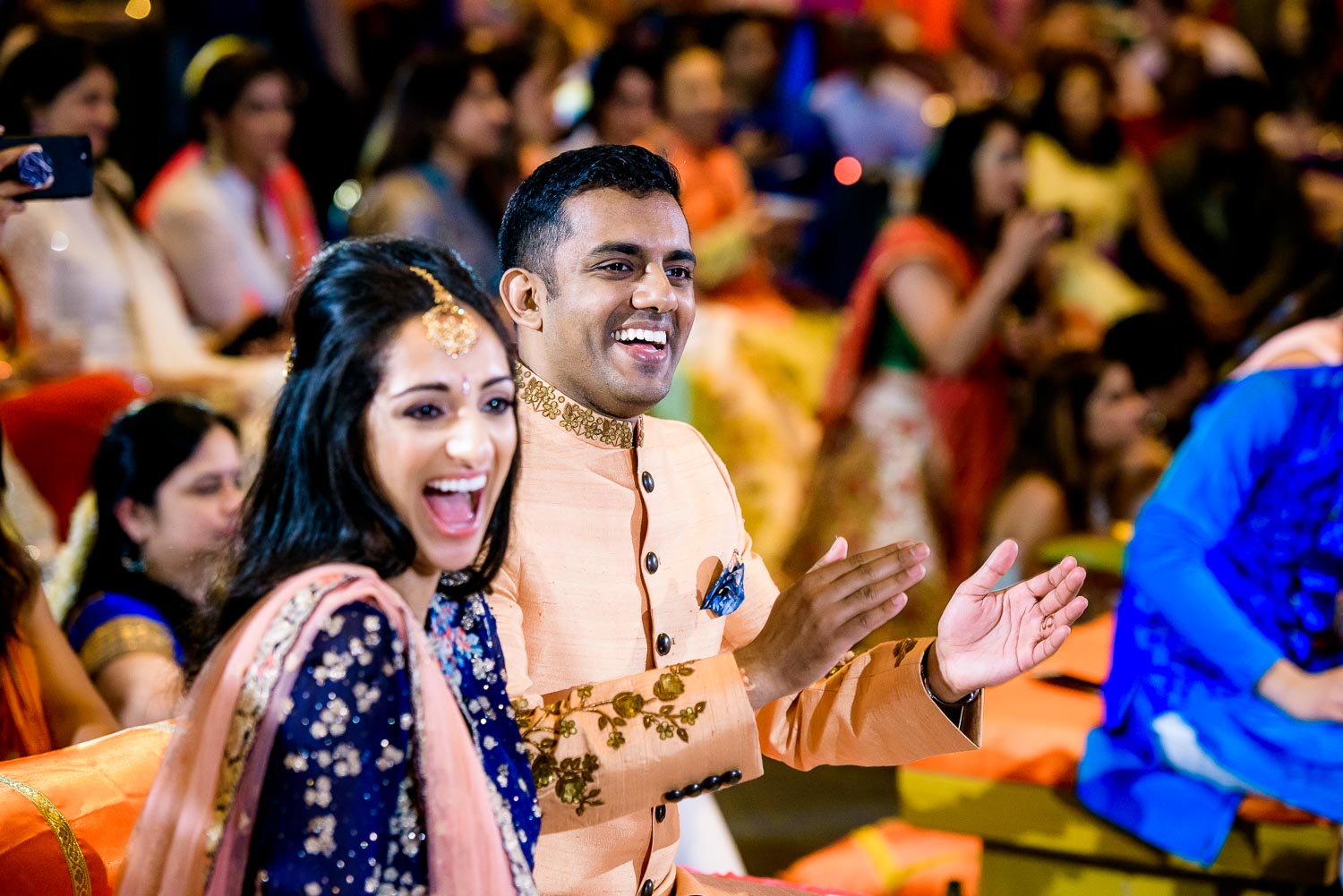 Bride and groom share a laugh during an Indian wedding sangeet at Stonegate Banquets in Hoffman Estates. 