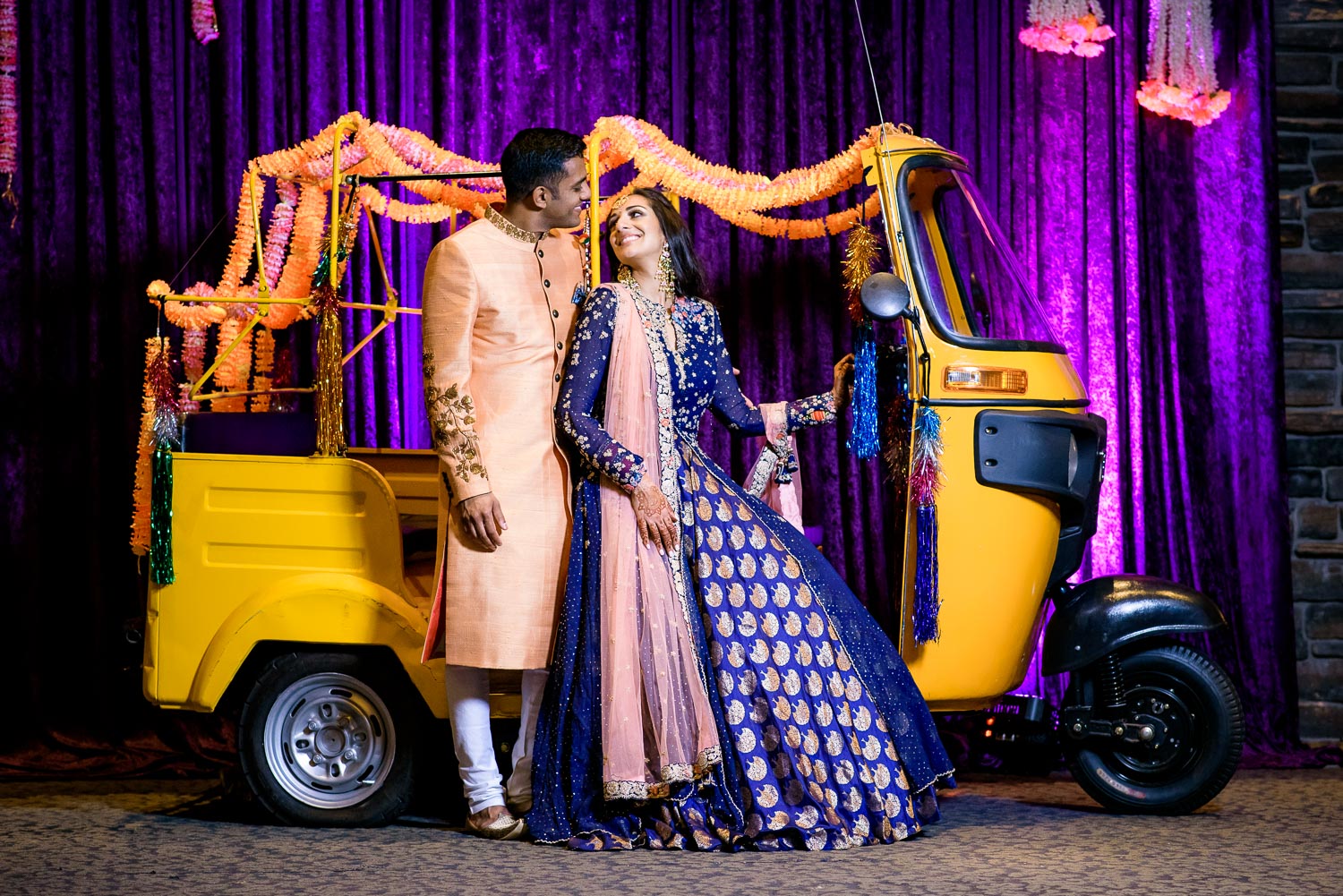 Bride and groom portrait with rickshaw during an Indian wedding sangeet at Stonegate Banquets in Hoffman Estates. 