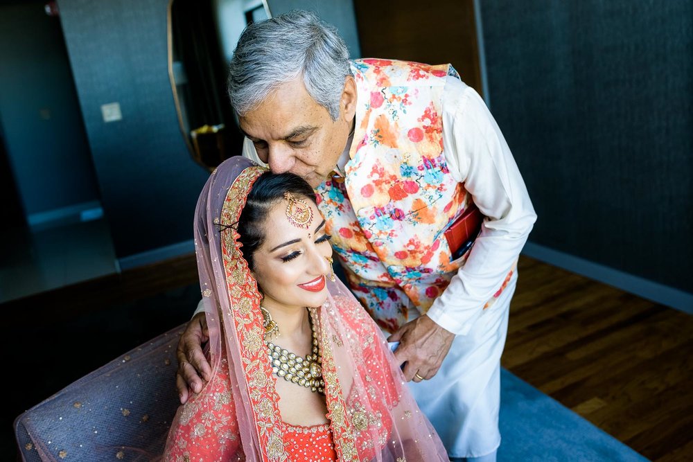 Father kisses the bride before her Renaissance Schaumburg Convention Center Indian wedding.