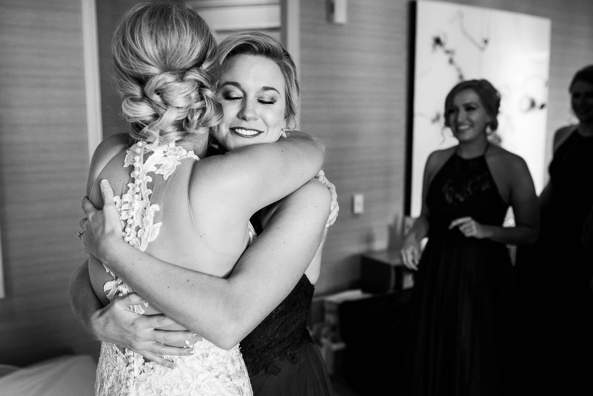 Bride and bridesmaid hug while getting ready before a Mid America Club wedding in Chicago.