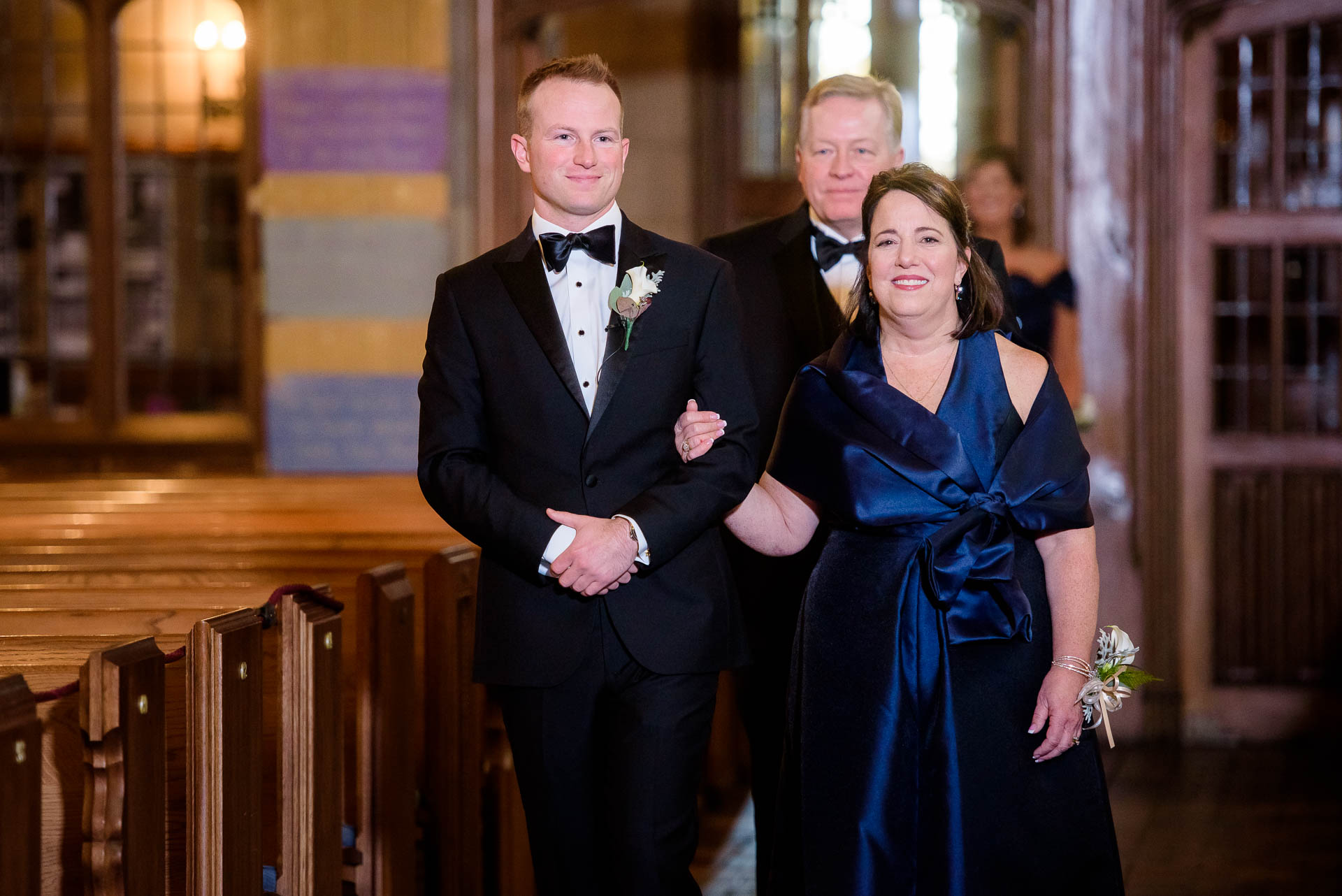 Groom and mother walk down the aisle during a wedding ceremony at Fourth Presbyterian Church in Chicago.
