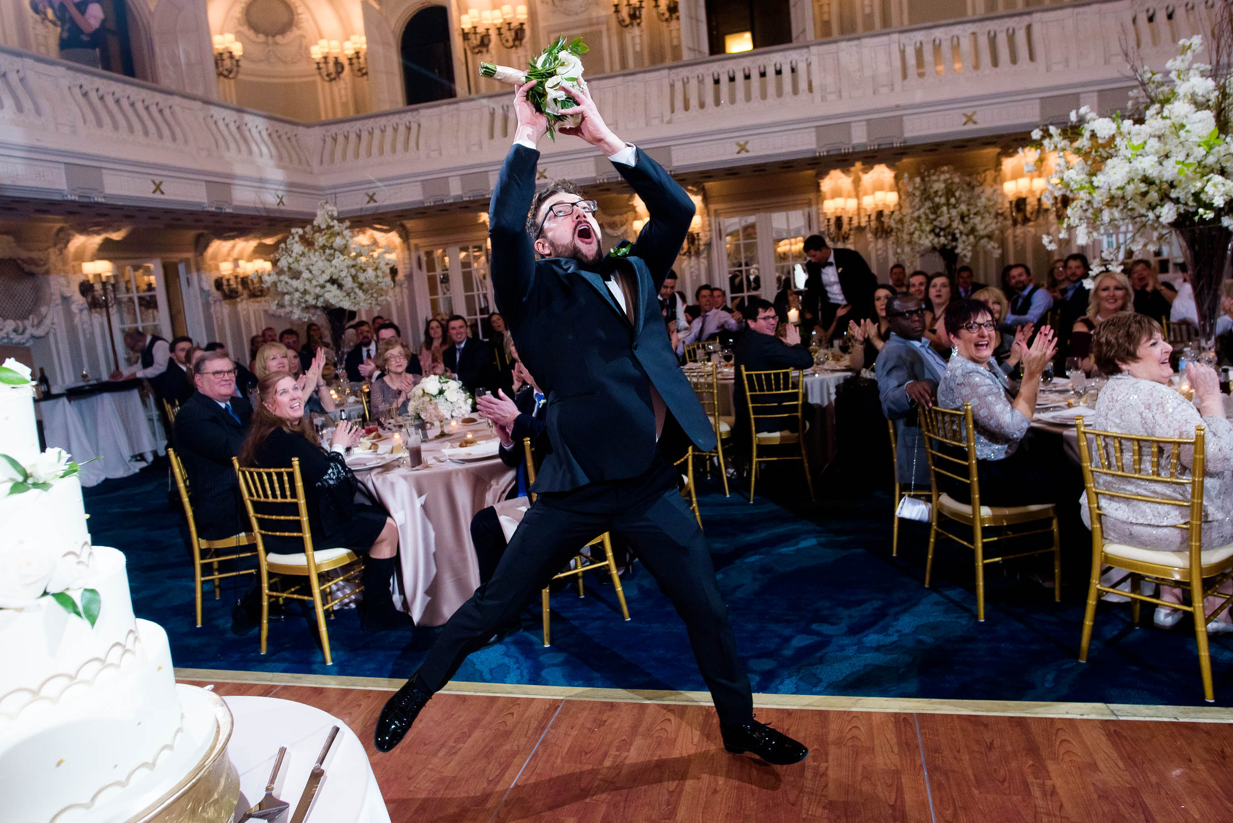 Groomsman catches a bouquet during a Blackstone Chicago wedding.