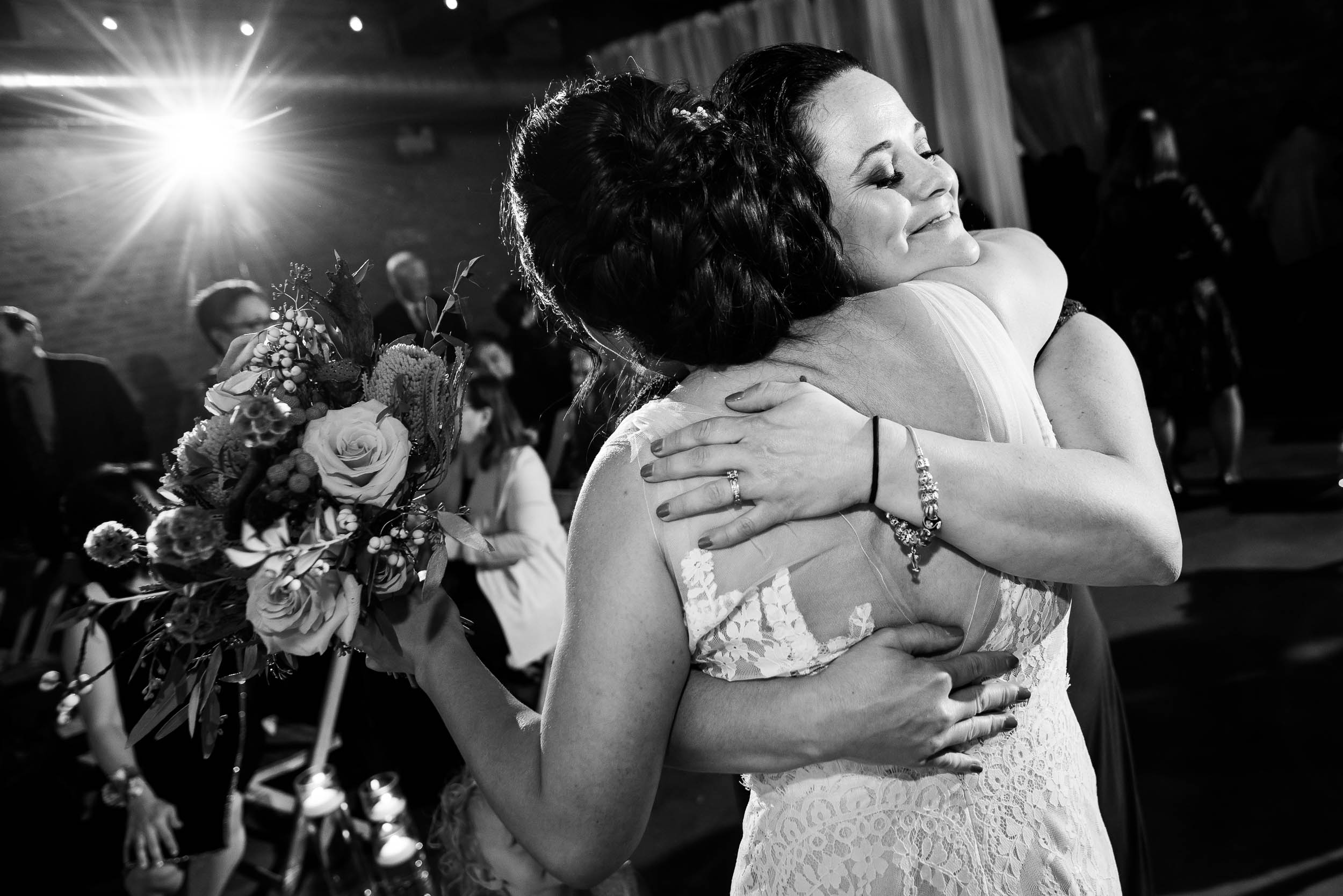 Sisters hug during a Loft on Lake Chicago wedding.