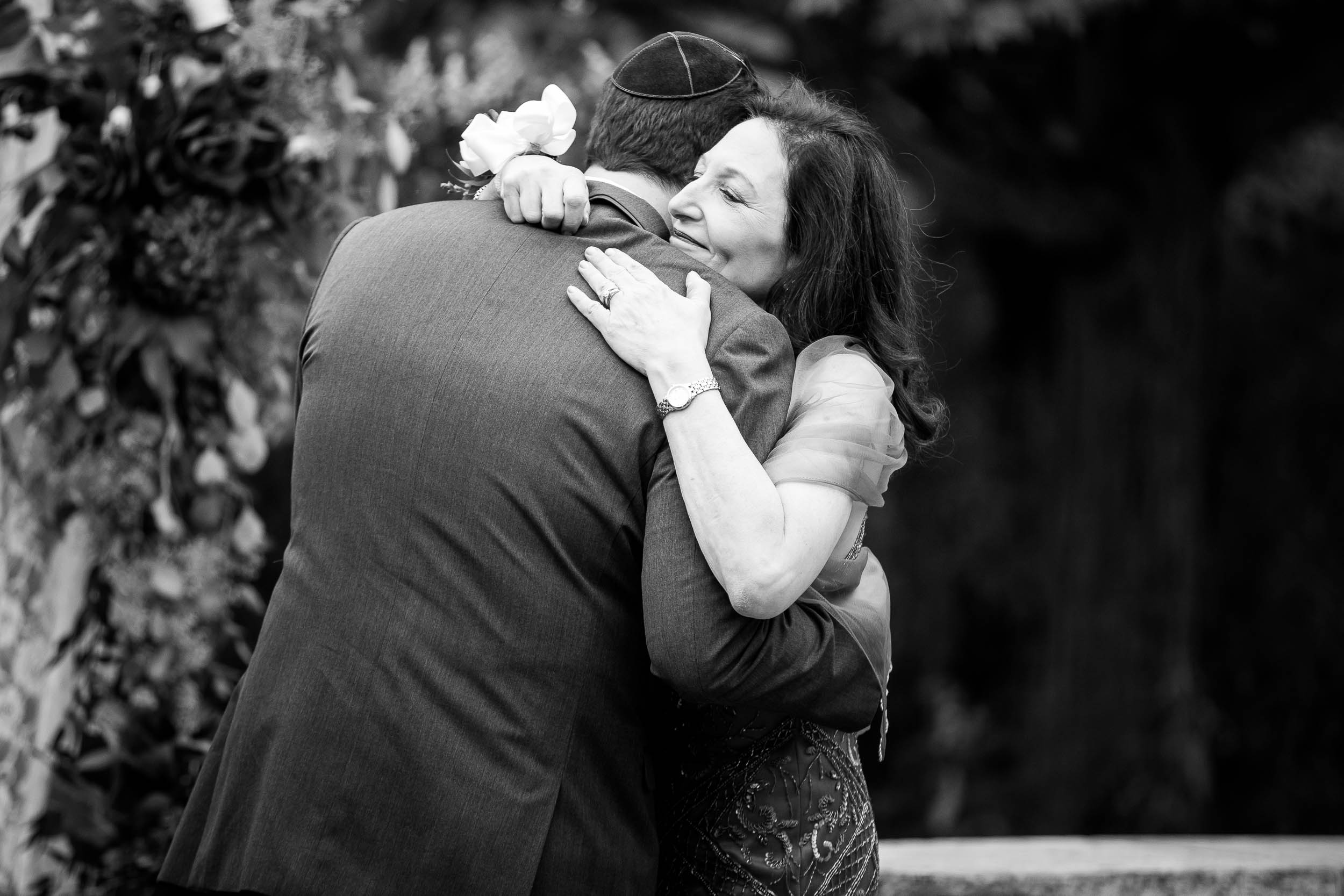 Mother and groom hug during an Independence Grove Chicago wedding.  