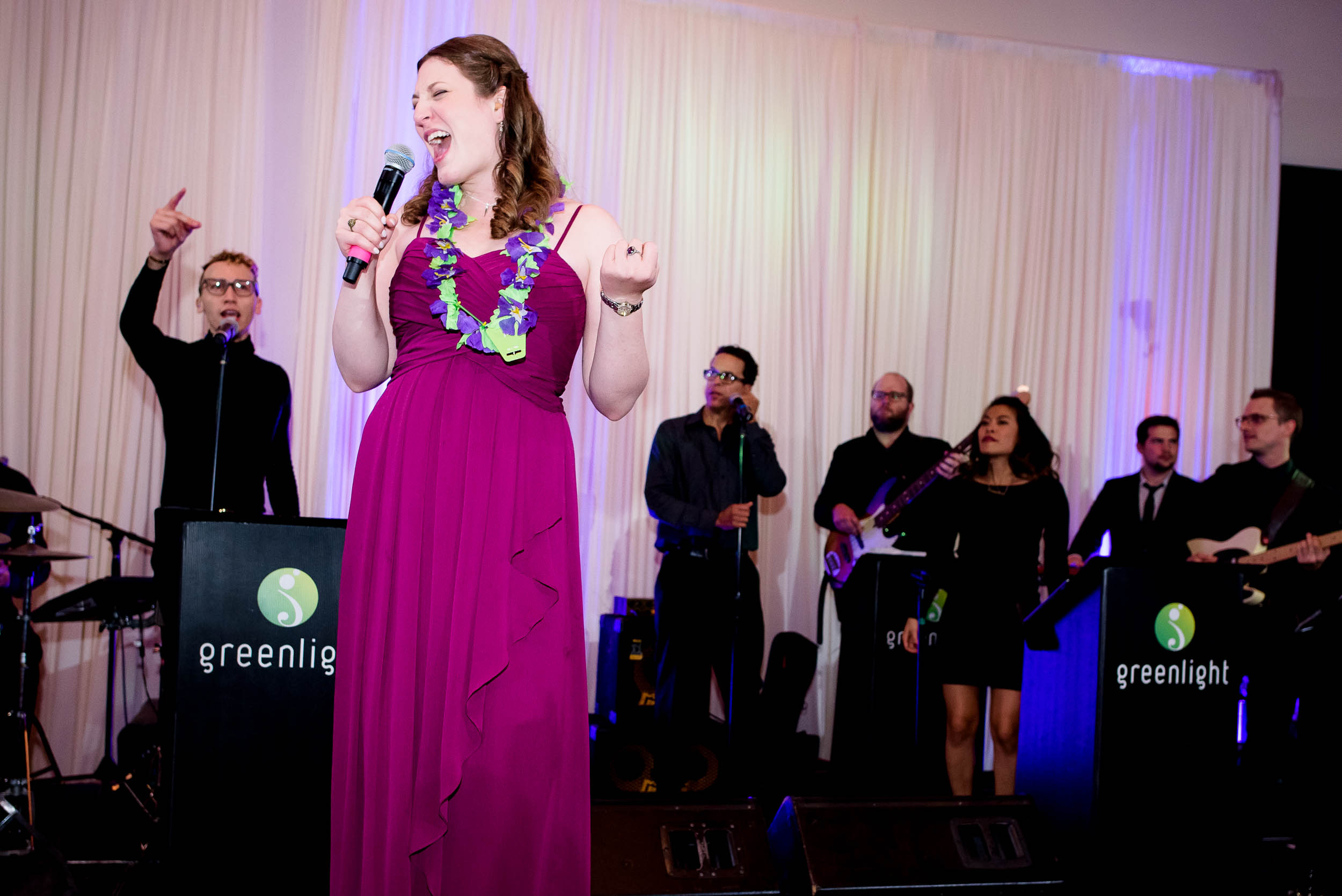 Maid of honor sings with Greenlight band during an Independence Grove Chicago wedding.  
