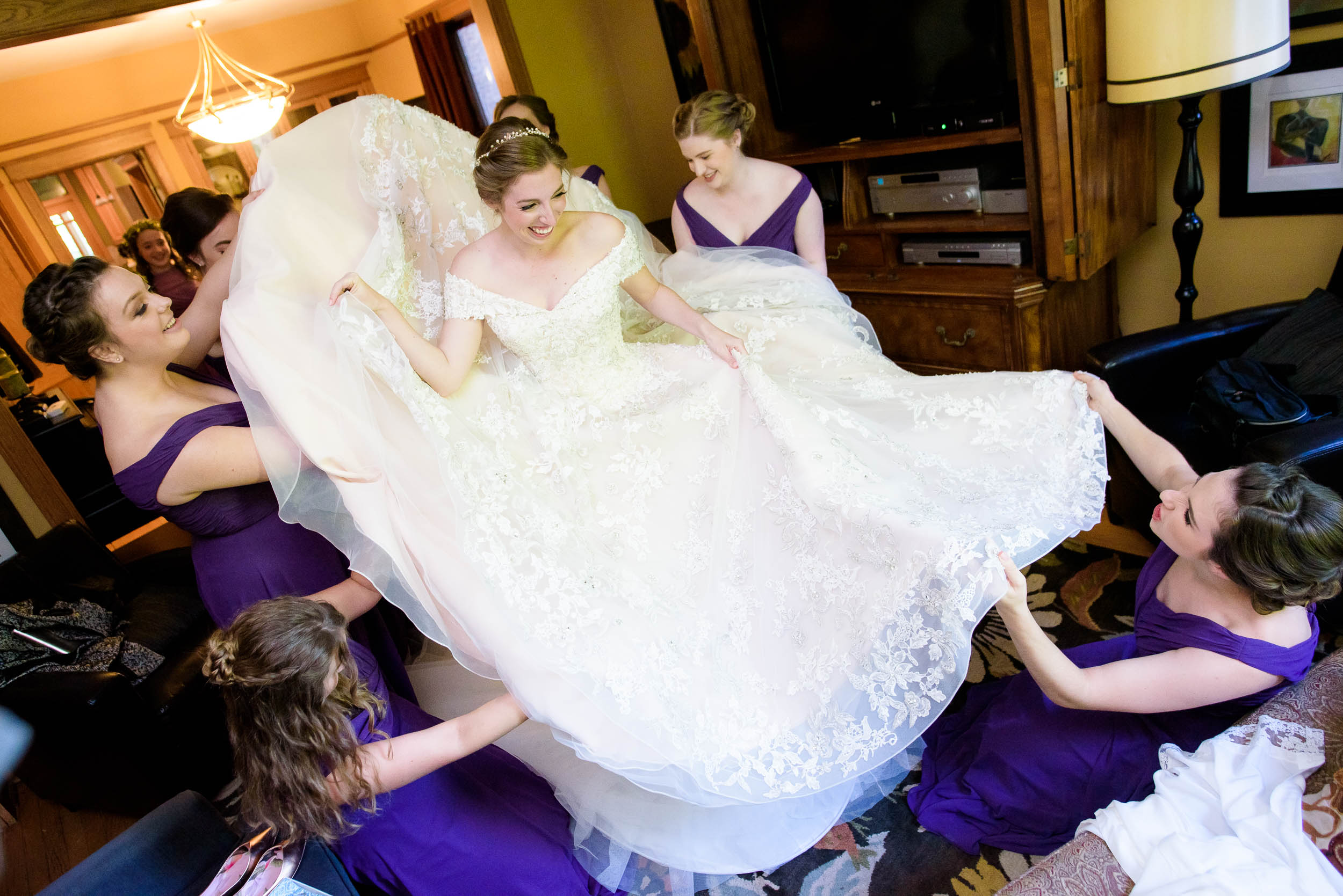 Bridesmaids help the bride with her dress during a Newberry Library Chicago wedding.
