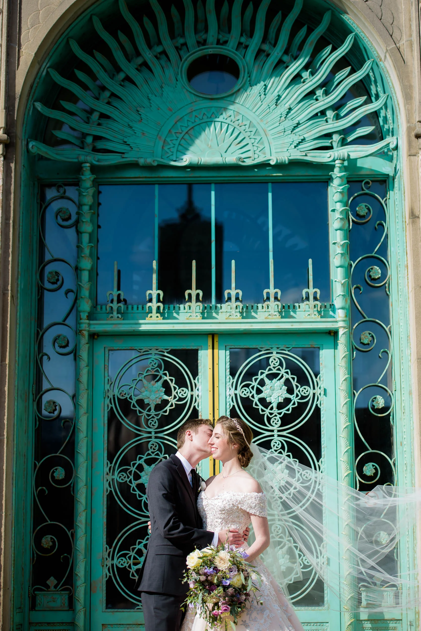 Wedding day portrait outside the green doors of Loyola's Cudahy Library.