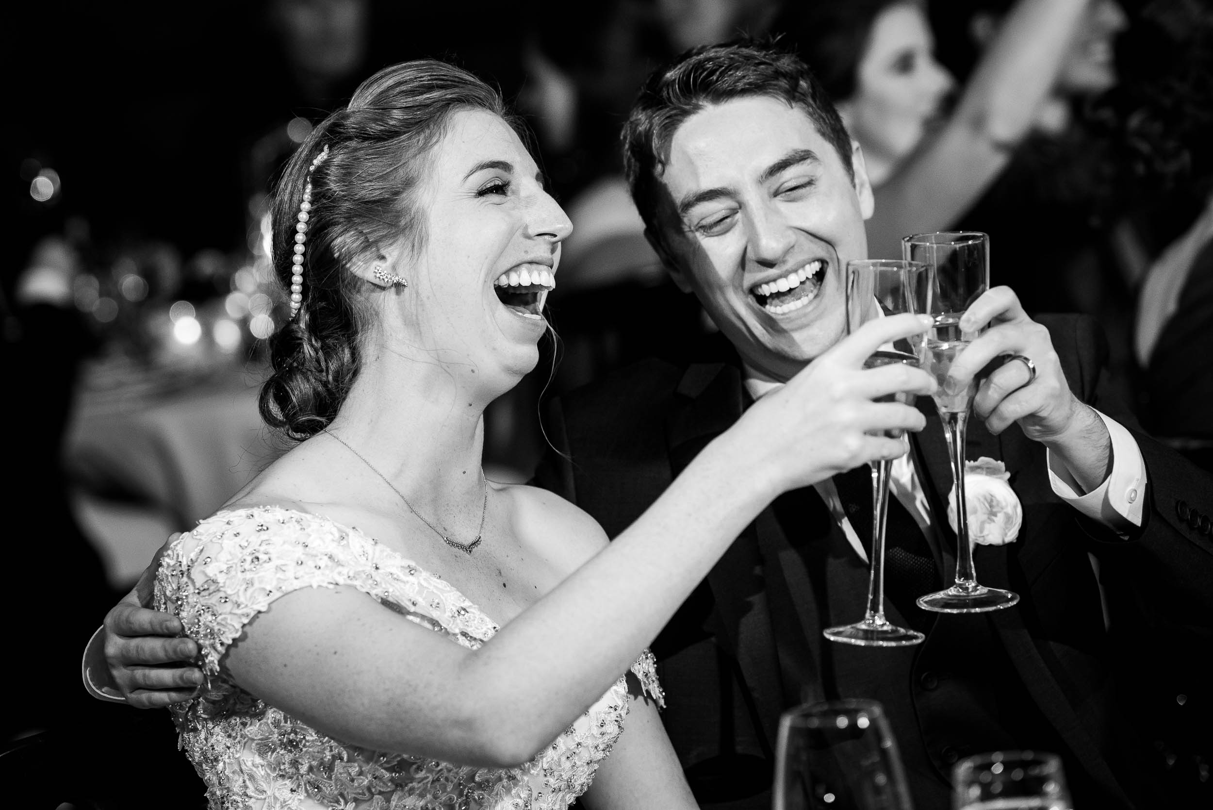 Bride and groom laugh during toasts during a Newberry Library Chicago wedding.