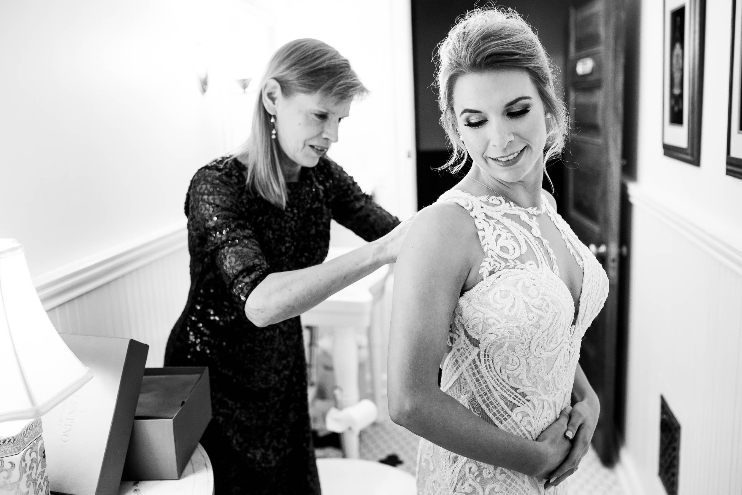Bride and mom putting on the wedding dress during a Glessner House Chicago wedding.