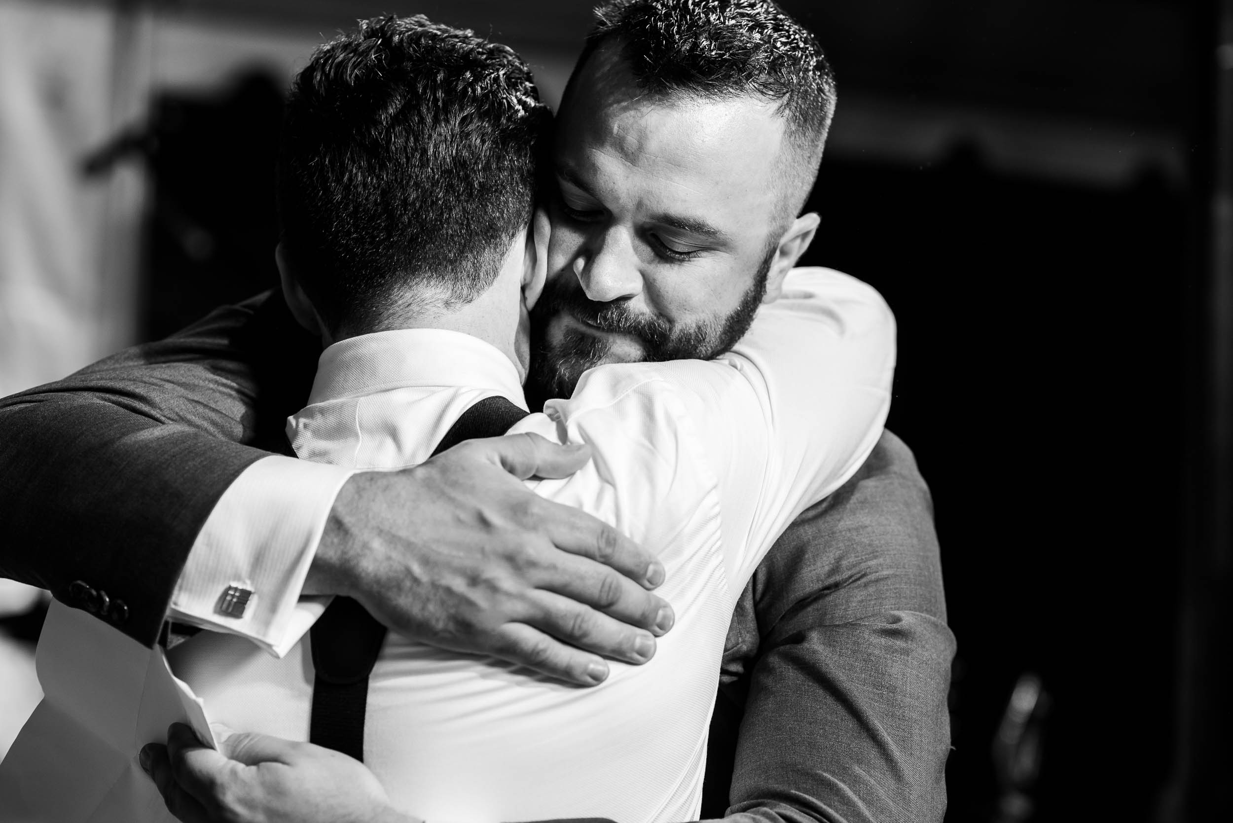Groom and best man hug during a Glessner House Chicago wedding reception.