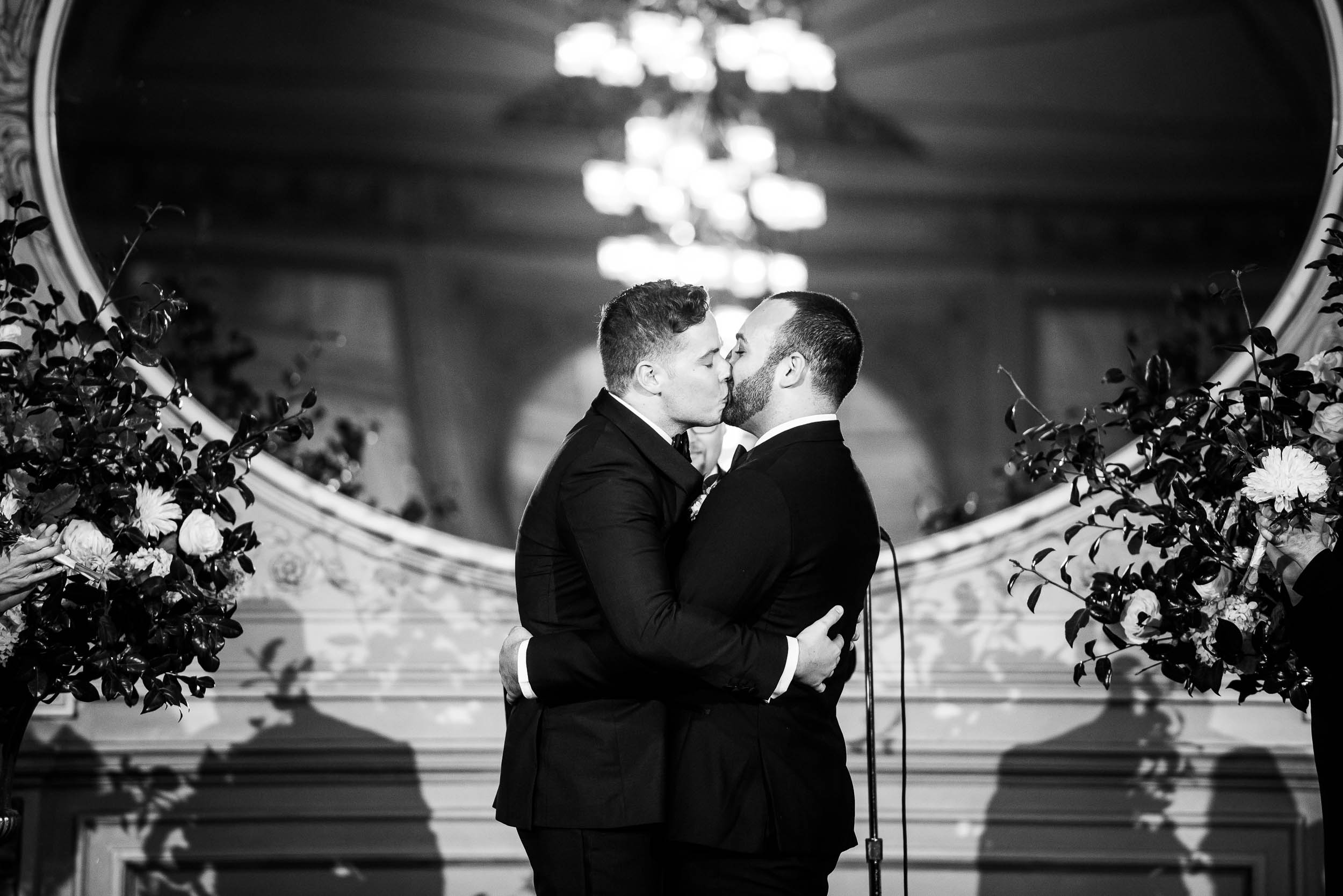 Grooms share a kiss at luxurious fall wedding at the Chicago Symphony Center captured by J. Brown Photography. See more wedding ideas at jbrownphotography.com!