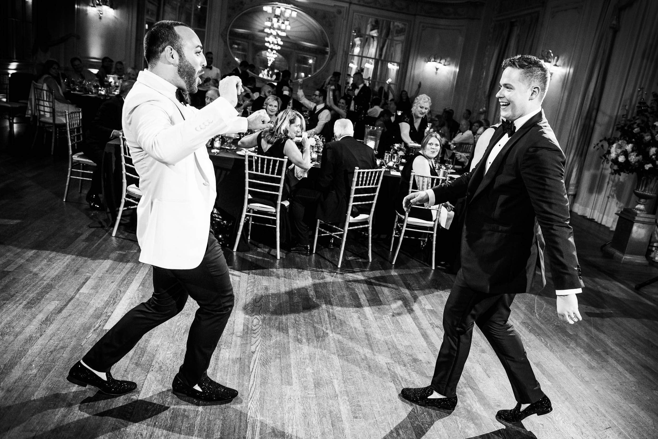 Grooms celebrating at luxurious fall wedding at the Chicago Symphony Center captured by J. Brown Photography. See more wedding ideas at jbrownphotography.com!