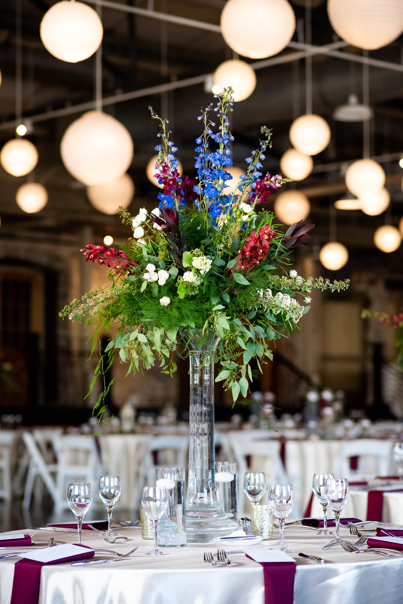 Tall wedding centerpieces: Modern industrial Chicago wedding inside Prairie Street Brewhouse captured by J. Brown Photography. Find more wedding ideas at jbrownphotography.com!