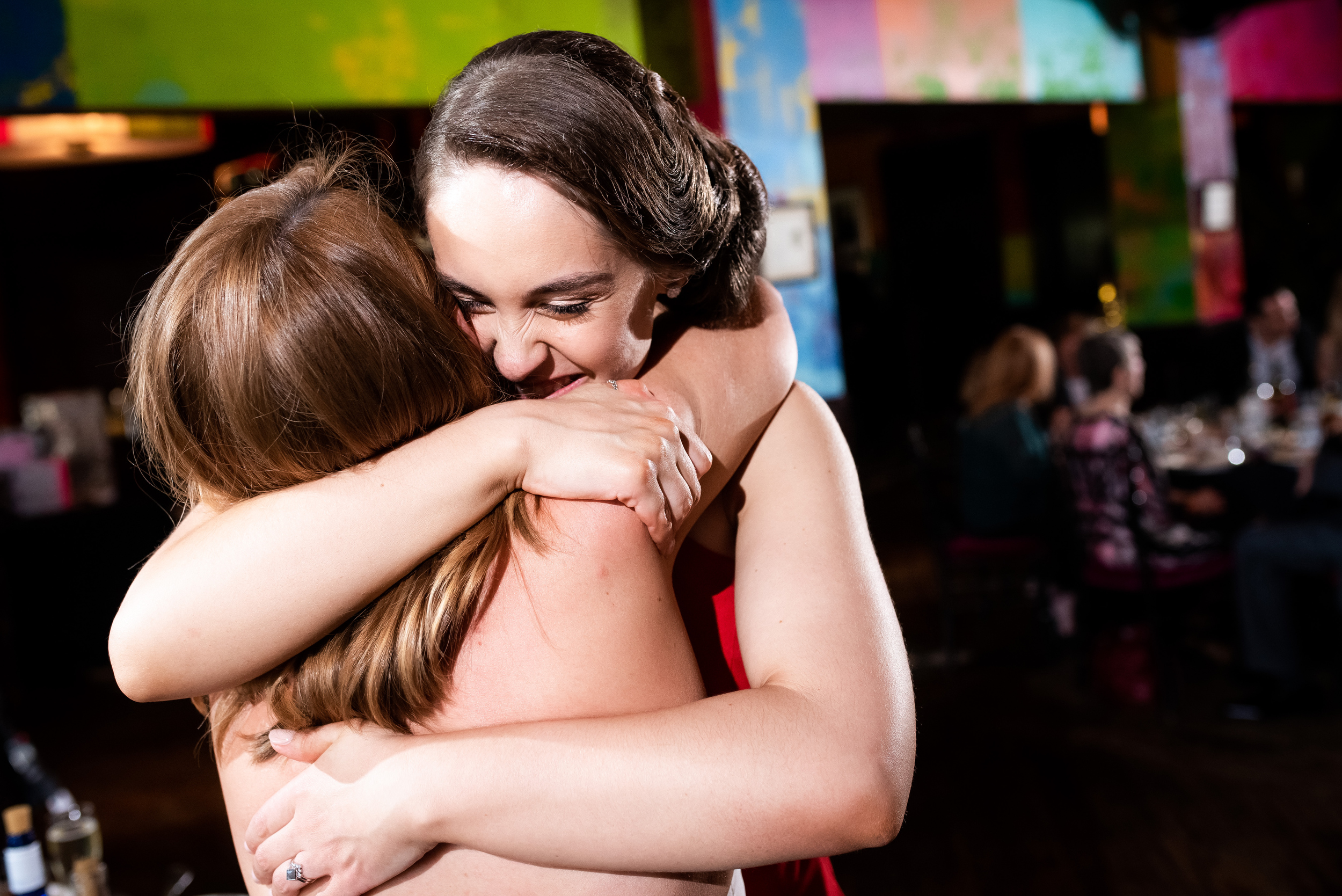 Maid of honor and bride share a hug for Carnivale Chicago wedding captured by J Brown Photography