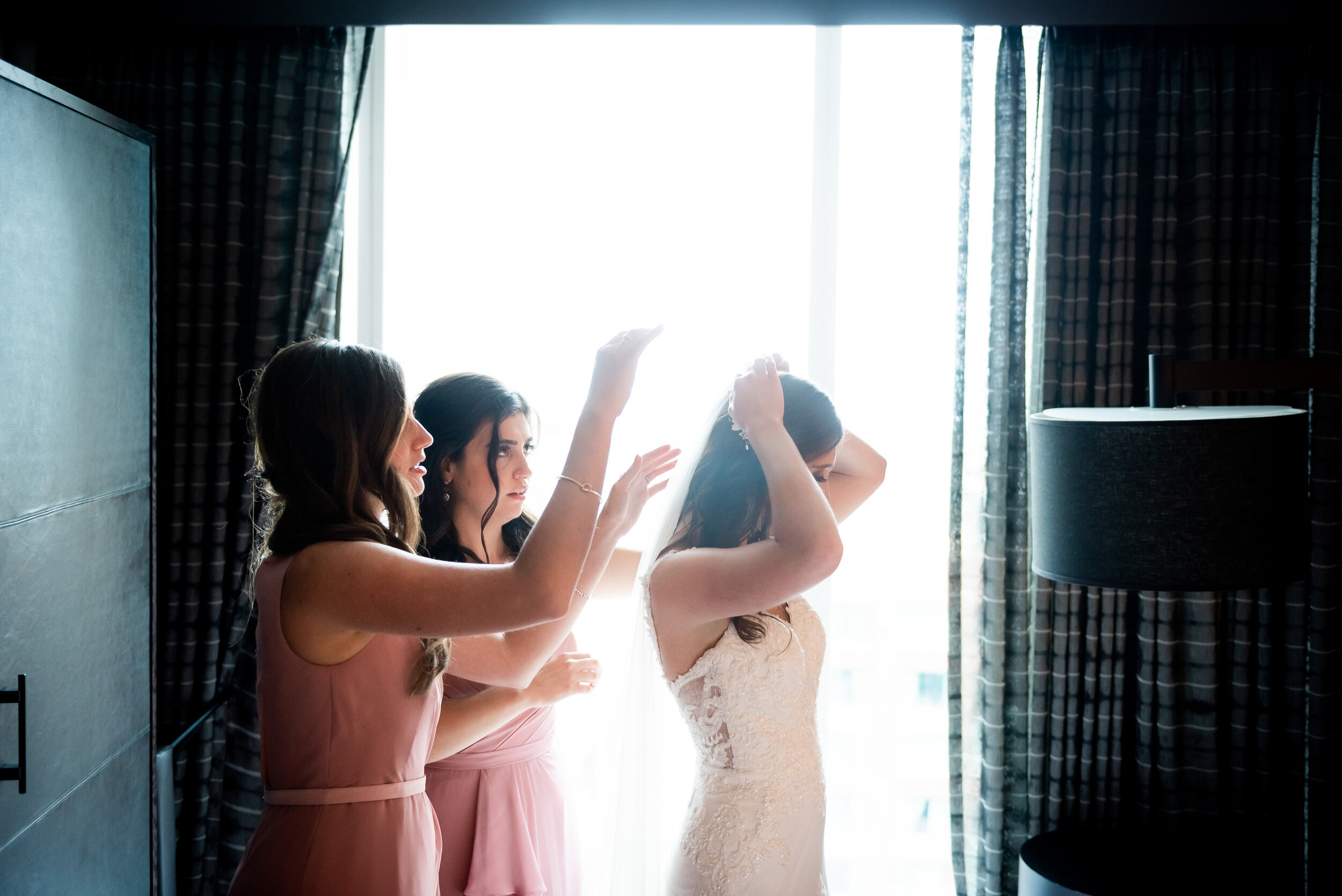 Bride getting ready with bridesmaids: Loews Chicago Hotel Wedding captured by J. Brown Photography