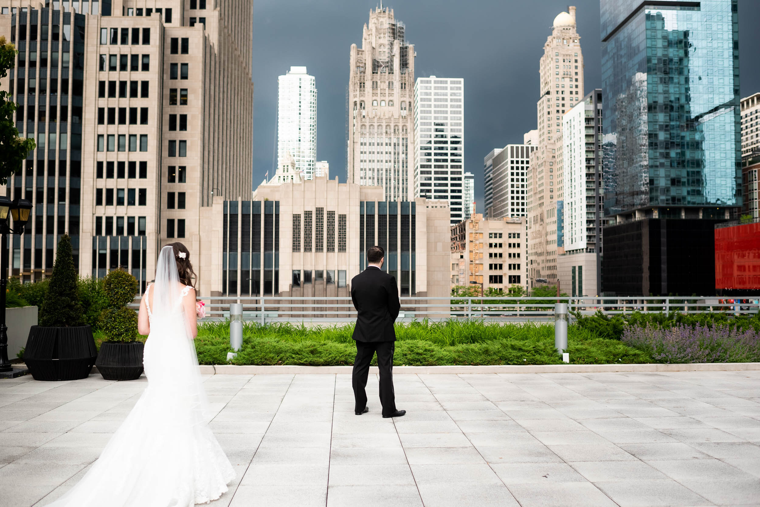 Wedding first look with stormy skies and Chicago skyline: Loews Chicago Hotel Wedding captured by J. Brown Photography