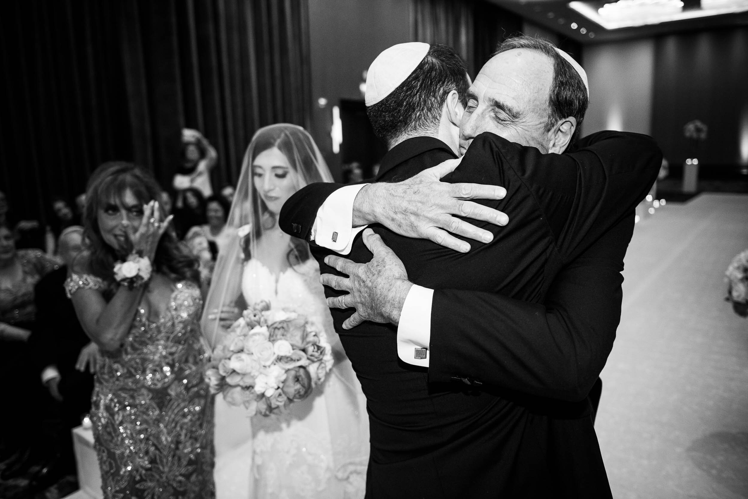 Father of the groom and groom sharing a hug: Loews Chicago Hotel Wedding captured by J. Brown Photography