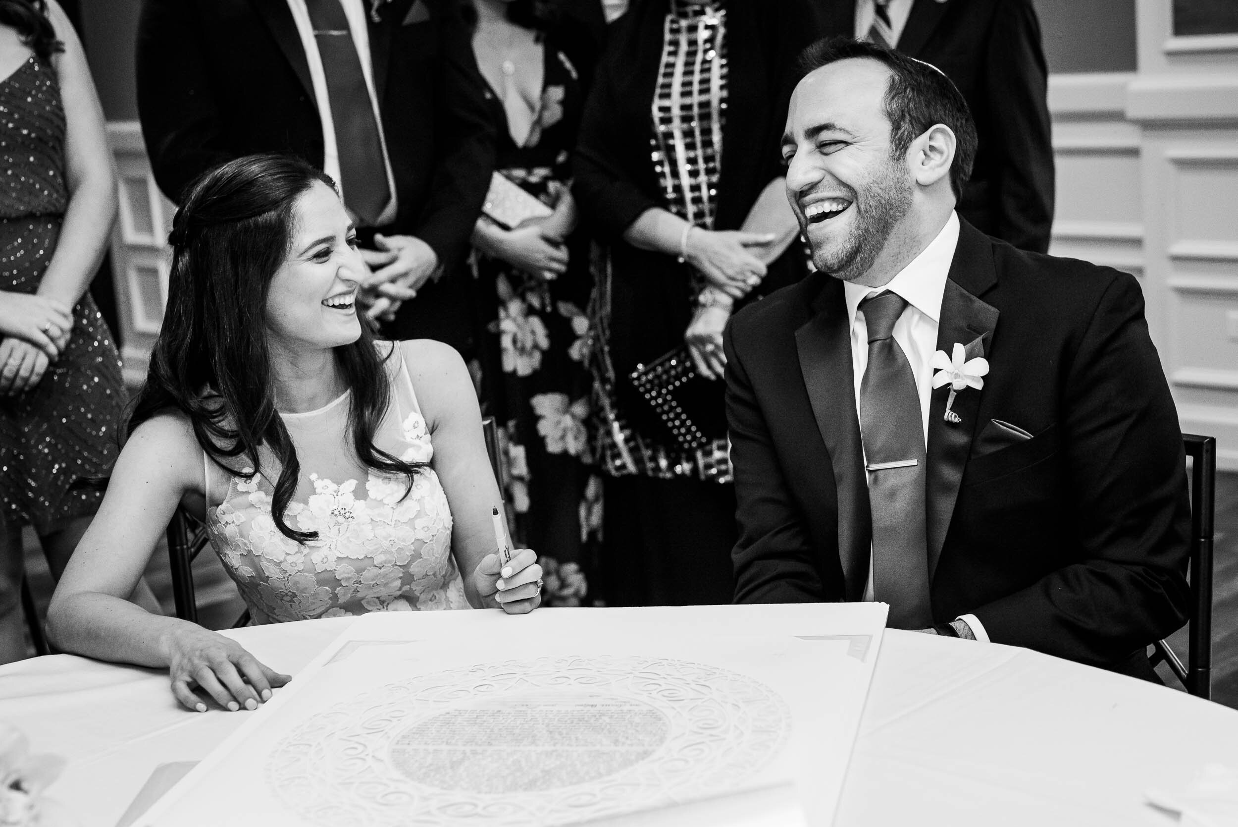 Fun moment at ketubah signing during a Chevy Chase Country Club wedding by J. Brown Photography.