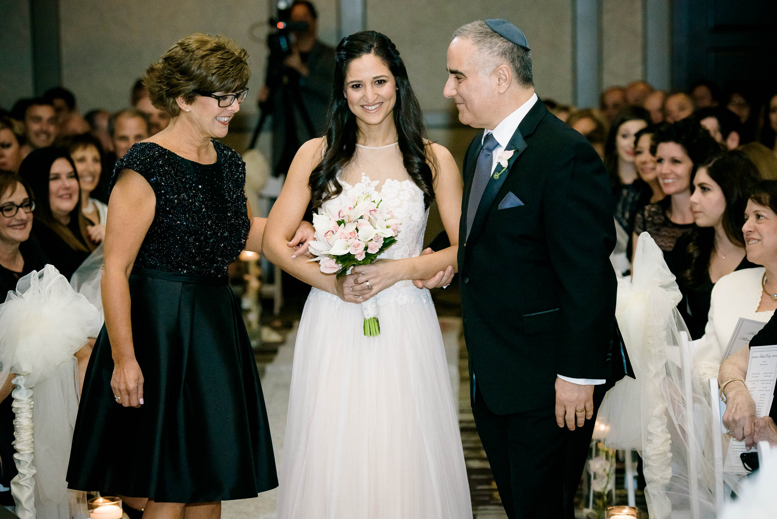 Bride walks down aisle with parents during a Chevy Chase Country Club jewish wedding by J. Brown Photography.