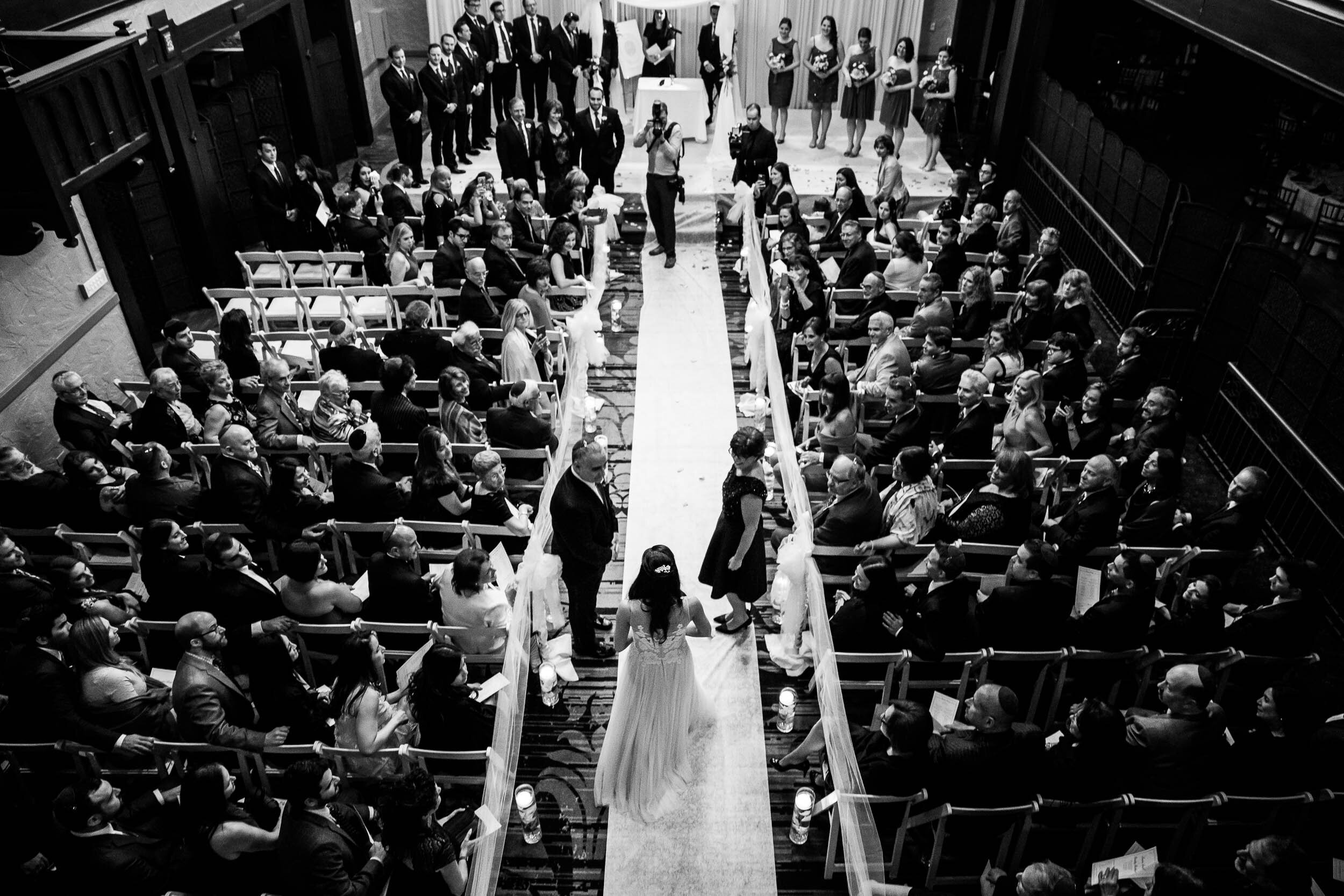 Bride walks down aisle during a jewish Chevy Chase Country Club wedding by J. Brown Photography.